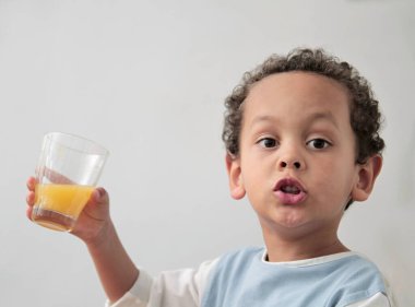 Bir bardak portakal suyu içen çocuk sağlıklı beslenmeyi teşvik ediyor.