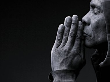 dindar kıdemli Karayipli adam stüdyoda karanlık arka plan için dua ediyor.