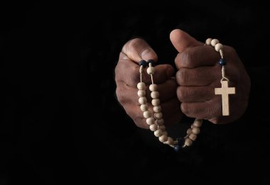 Ellerinde haç, dua ve inanç konsepti olan Hıristiyan tespihi.