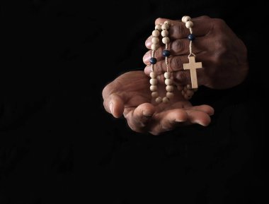 Ellerinde haç, dua ve inanç konsepti olan Hıristiyan tespihi.