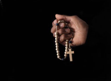 Elinde haç, dua ve inanç olan Hıristiyan tespihi.