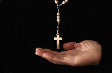 Karanlık arka planda dua eden el ve haç, Hıristiyan inancı kavramı