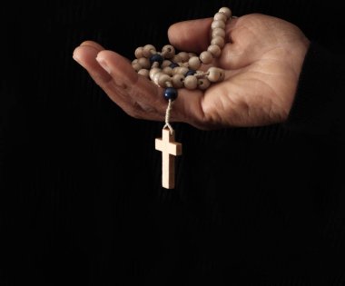 Elinde haç, dua ve inanç olan Hıristiyan tespihi.