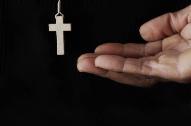 Karanlık arka planda dua eden el ve haç, Hıristiyan inancı kavramı