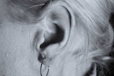 Gri arka planda sağırlık ve işitme kaybı yaşayan kadın.