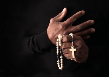 Ellerinde haç, dua ve inanç konsepti olan Hıristiyan tespihi.