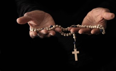 Ellerinde haç, dua ve inanç konsepti olan Hıristiyan tespihi.
