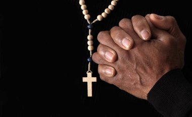 Karanlık arka planda dua eden eller ve haç, Hıristiyanlık inancı kavramı