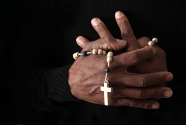 Ellerinde haç, dua ve inanç konsepti olan Hıristiyan tespihi.