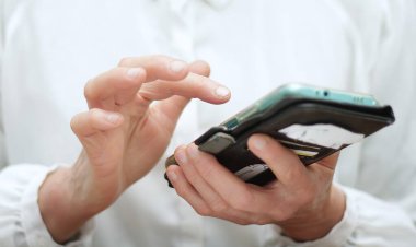 Akıllı telefonu elinde tutan kişinin yakın görüntüsü