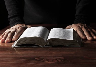 İncille Tanrı 'ya dua eden bir adam, Tanrı' ya dini inancını gösterir.