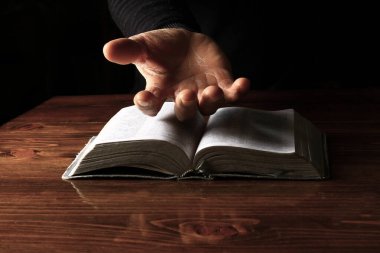 Adam İncil 'le dua ediyor, Tanrı' ya dini inancını gösteriyor.