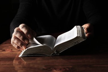 Adam İncil 'le dua ediyor, Tanrı' ya dini inancını gösteriyor.