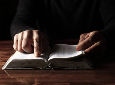 Adam İncil 'le dua ediyor, Tanrı' ya dini inancını gösteriyor.