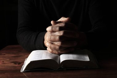 Adam İncil 'le dua ediyor, Tanrı' ya dini inancını gösteriyor.