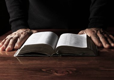 Adam İncil 'le dua ediyor, Tanrı' ya dini inancını gösteriyor.