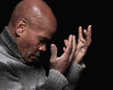 Siyah arka plan, inanç ve maneviyat kavramı için Tanrı 'ya dua eden bir adam.