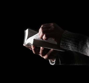 Adam İncil 'le dua ediyor, Tanrı' ya dini inancını gösteriyor.