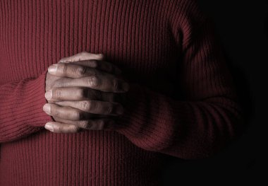 Siyah arkaplana karşı el ele tutuşan kişi