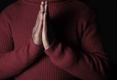 Siyah arka plan, inanç ve maneviyat kavramı için Tanrı 'ya dua eden bir adam.