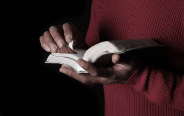 Adam İncil 'le dua ediyor, Tanrı' ya dini inancını gösteriyor.