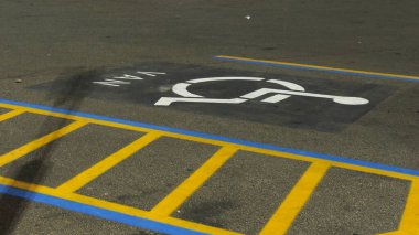 Akşamları kaldırımda engelli park levhası.