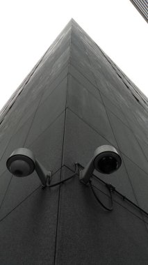 Güvenlik kameraları olan uzun ve modern bir bina.