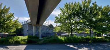 Gündüz vakti açık mavi gökyüzünün altındaki bir köprünün yüksek açılı görüntüsü.