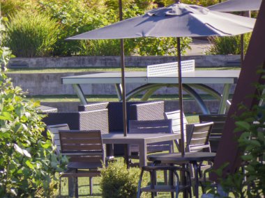 Sandalyesi, masası ve bahçesi olan modern bir bahçe.