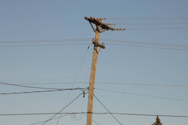 Mavi gökyüzünün arka planında elektrik hatları ve kablolar