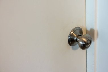 Evde fırçalanmış metal kapı tokmağı olan beyaz kapı.