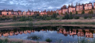 Tepedeki evler bir banliyö gölüne yansıyor