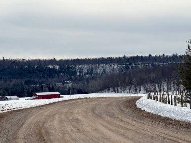 Kışın karlı bir tarlası olan bir yol