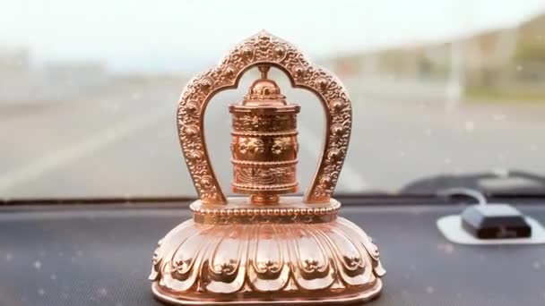 移動乗用車のダッシュボード上の仏教の自動黄金の祈りホイールを閉じると 現代の生活の中で軸 伝統的な宗教的な要素やシンボルについて回転します — ストック動画