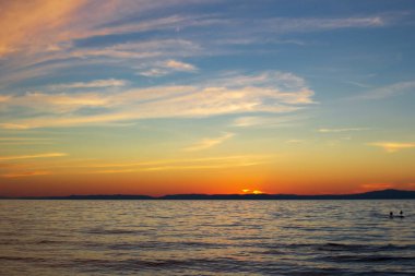 Baykal Gölü 'nde karanlık manzaralı bir gün batımı. Mavi gökyüzü. Güneş battı.