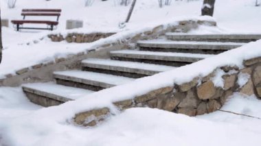 Kış parkında kar yağışı, soğuk kar mevsiminde kar yağışı olan taş merdivenler.