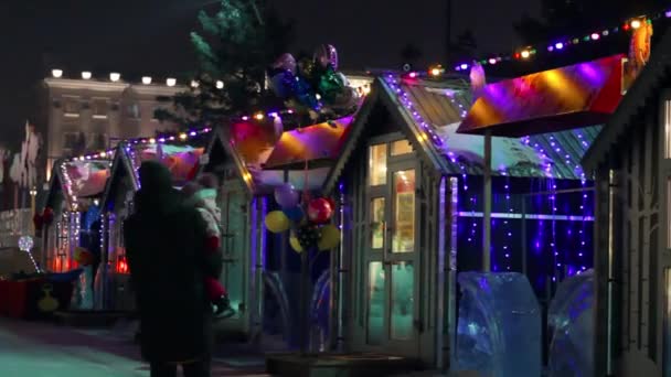 Mercado urbano de Navidad en la noche oscura, luces de guirnalda e iluminación en la feria navideña de Navidad — Vídeos de Stock