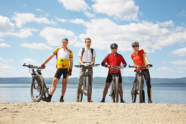 Men with bike on a mountain lake — Stock Photo, Image