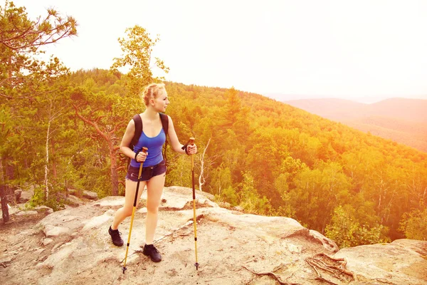 Žena s batohem turistika v horách — Stock fotografie
