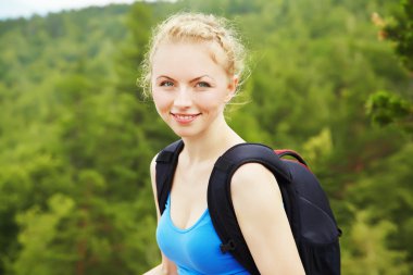 Sırt çantalı bir kadın dağda yürüyüş yapıyor.