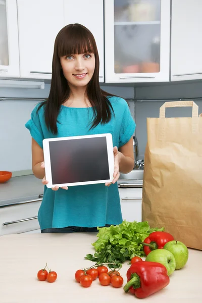Ama de casa utiliza una tableta en la cocina —  Fotos de Stock