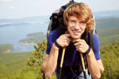 Sırt çantalı bir adam dağda yürüyüş yapıyor.