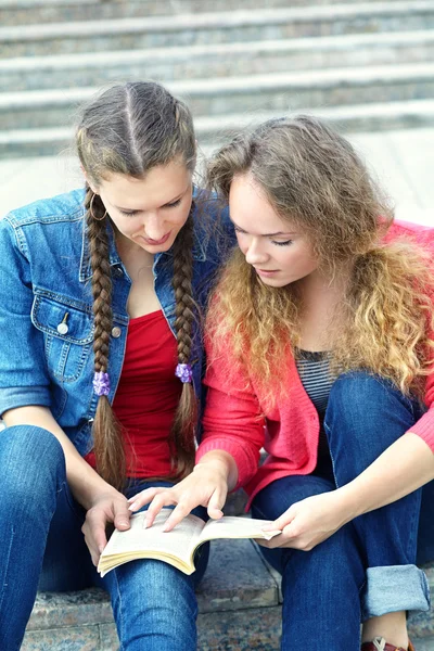 Duas namoradas lendo um livro — Fotografia de Stock