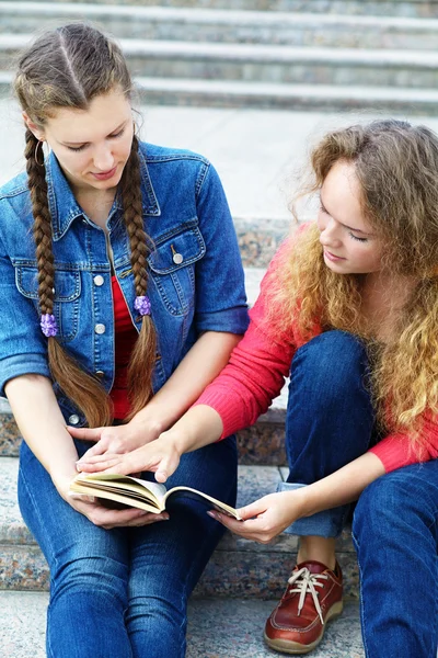 Two girlfriends reading a book — Stock Photo, Image