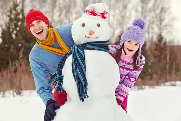 Vader en dochter met sneeuwpop — Stockfoto