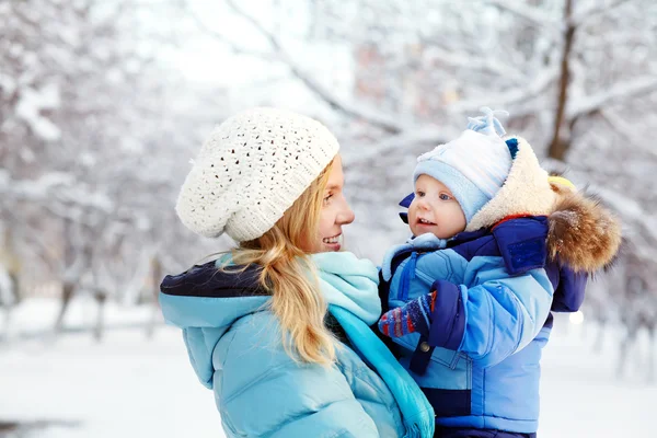 Happy mother and baby in winter park — Stock Photo, Image