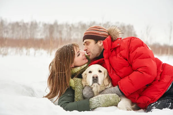 Porträt eines jungen Paares mit Hund bei einem Winterspaziergang. Mann und Frau mit Labrador — Stockfoto