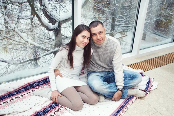 Uomo e donna vicino alla finestra a casa. coppia in inverno. — Foto Stock