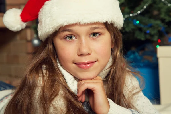 Carino ragazza adolescente in cappello di Babbo Natale vicino all'albero di Natale. bambino di Natale. — Foto Stock