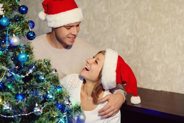 Jeune couple célébrant Noël à la maison. homme et femme dans avec un coffret cadeau — Photo